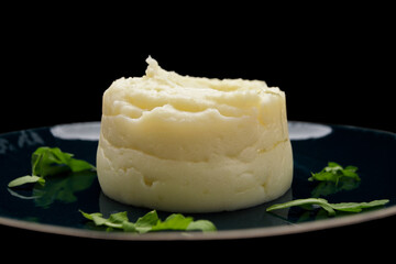 Mashed potatoes on a plate, on a dark background
