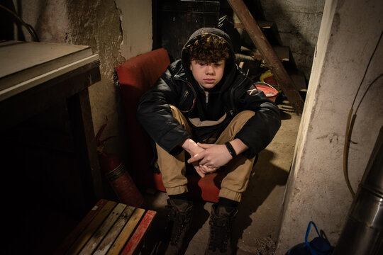 Teenager boy sits in a basement during the bombings in Ukraine. War. Russian aggression and terror. Children are psychologically traumatized. Genocide of the Ukrainian people. Bombing civilians. Noise