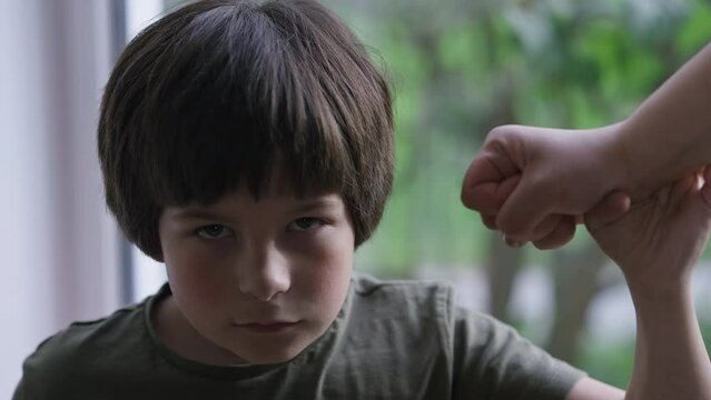 Close-up Confident Little Boy Stops Fist Looking At Camera With Serious Facial Expression. Portrait Of Caucasian Son Resisting Aggressive Parent Abuse. Self Protection And Child Abuse Concept