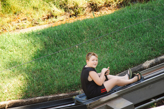 Kids Riding The Toboggan Attraction On A Family Road Trip At The Big Banana Fun Park, Coffs Harbour Australia