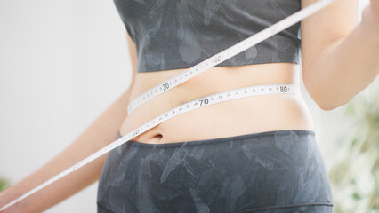 ウエストサイズをメジャーで測る女性　ビューティーイメージ