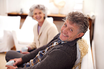 Obraz premium Home sweet home. Portrait of a loving senior couple sitting together in their lounge.