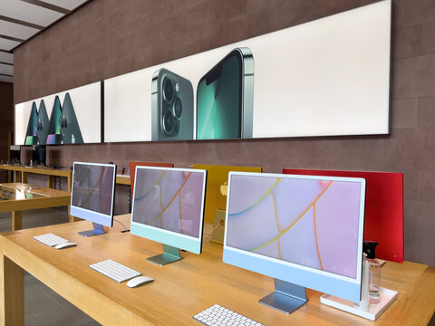 Paris, France - Mar 18, 2022: Advertising for the new sophisticated alpine green iPhone 13 Pro range 5G during the sales launch at the Apple Inc. flagship store wiew through multiple iMac