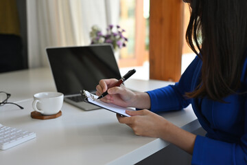 Cropped view businesspeople sitting and working on a tablet together, for financial , insurance and technology concept.