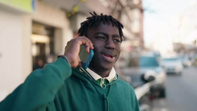 African american man smiling confident talking on the smartphone at street