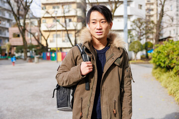 リュックサックを背負って歩いている日本人男性
