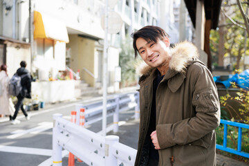 ガードレールによりかかる日本人男性