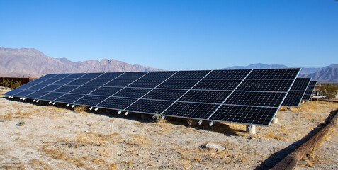 A large rack with solar panels on the ground.