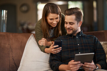 Get this app on your tablet. Cropped shot of a young couple using a cellphone and a digital tablet at home.