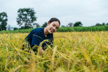 Naklejka na ściany i meble Portrait young female farmer in rice field