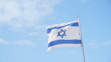 Israeli flag weaving in the wind against bright skies