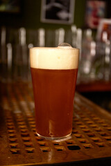 bartender pouring large lager beer. Light cold filtered beer in glass beaker.