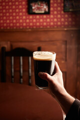 pint of stout. Craft beer in pub on wooden table. Glass of beer