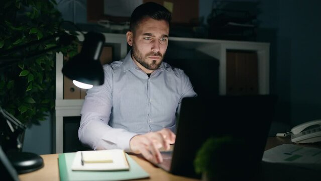 Young hispanic man business worker stressed working overtime at office