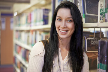 Time to do some studying. Portrait of a young female college student in a library.