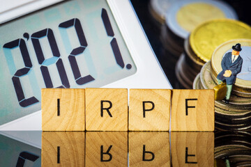 Income Tax Campaign 2021. Taxman sitting on coin stack. IRPF sign Macro