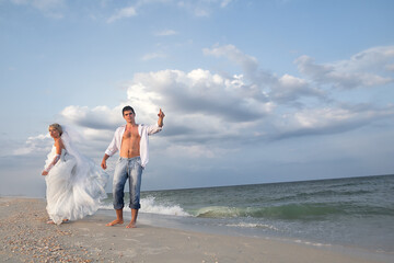 Bride and groom walking on a beautiful tropical beach