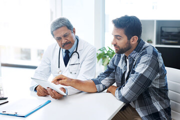 When last did you see a doctor. Shot of a mature male doctor and patient having a discussion in the...