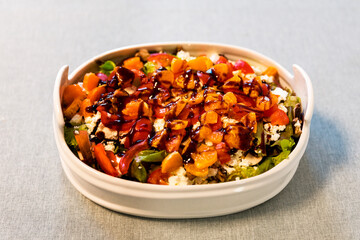 Leckeren Salat serviert in einer weißen Salatschüssel mit Mandarienen, Feta, Pilzen, und Basilikumsoße