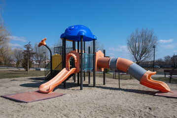 Children's playground in the park. Colorful plastic slide in the park