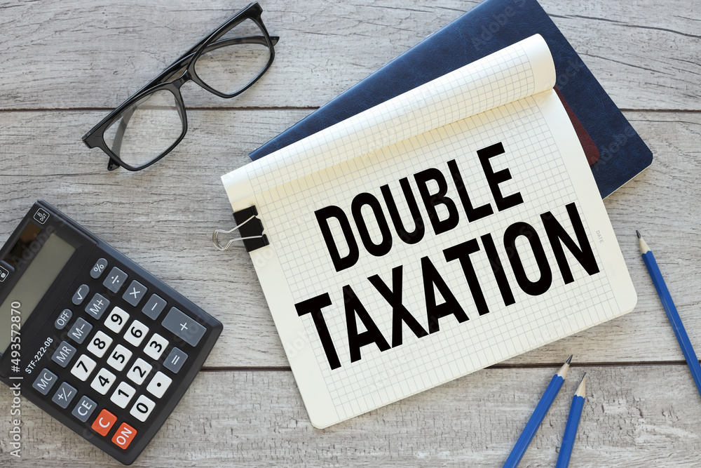 Poster two notepads. open notepad with text double taxation