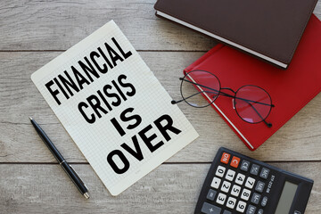 FINANCIAL CRISIS IS OVER, business concept. text on checkered paper on the desktop