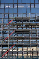 オフィスビルの外壁を修繕する建築用足場の風景