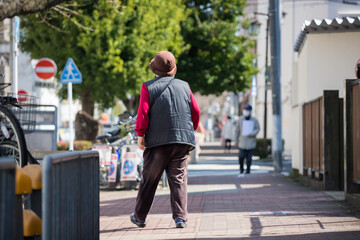 日本の町で散歩しているシニア女性の姿