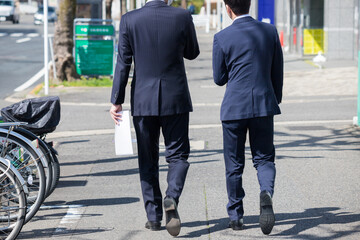 名古屋の街で歩いている二人のサラリーマンの姿