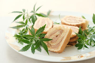 Sweet roll with marijuana oil on white plate. Cannabis kitchen. Layout of delicious dessert, top view close up.