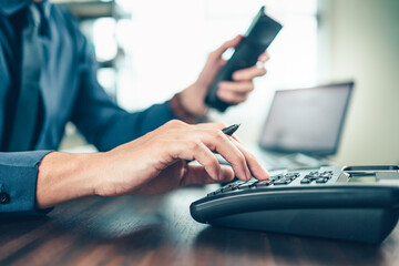 businessman dialing desk phone in the office. Telephone dialing ,contact and customer service.