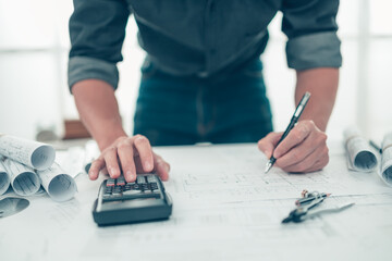 Architect engineer use calculator for calculate drawing design working on blueprint. House planning...