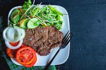 Grilled beef steaks and healthy salads on the table