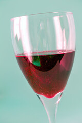 Glass with red wine isolated on green background.