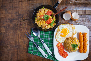 Cook American fried rice in a pan, served with fried eggs and sausages.