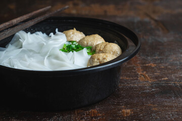 Noodles with meatballs on a wooden table