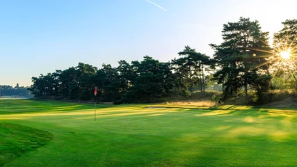 Fototapeten Golf course met ondergaande zon herfst schemering golfcourse © Peter