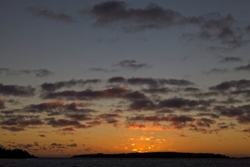Sunset with cloudy sky and silhouette of a island.