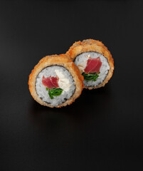 tempura maki sushi with tuna on black background closeup
