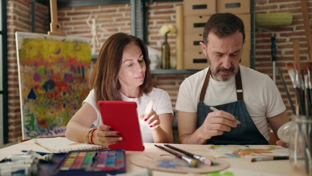 Man and woman couple drawing on notebook using touchpad at art studio