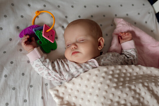 newborn baby covered with blanket sleeps in his crib with his favorite toy. healthy children's sleep without a pillow. happy carefree infancy. products for children, natural materials. space for text
