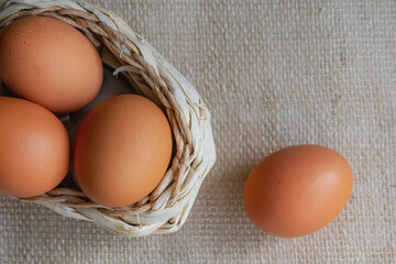 Brown eggs in a basket on a background of burlap