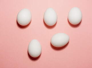 White eggs on a pink background