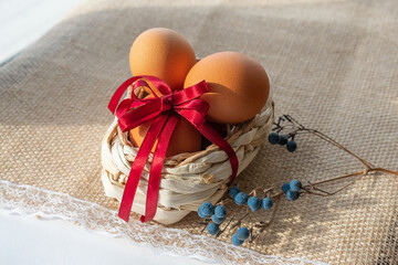 Easter eggs in brown color in a basket with a red ribbon