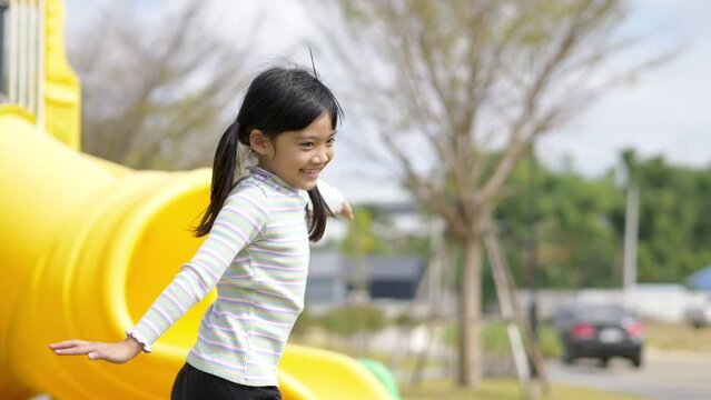 Two Asian cute girl run to play with extend the arms and smile with happy together at playground