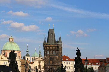 Tower of the Charles Bridge and ancient buildings in the city of Prague
