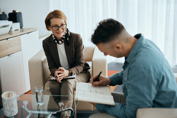 Happy mental health professional having counseling with patient in her office.