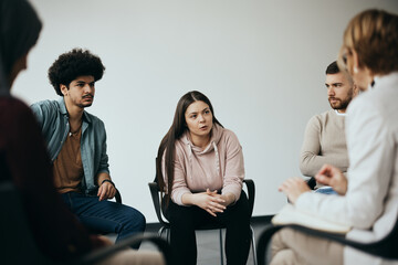 Young woman talks while having group therapy meeting at mental health center.