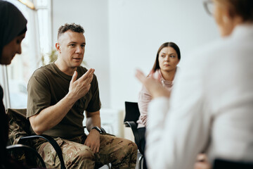 Mid adult veteran shares his story with attenders of group therapy at mental healthcare center. - obrazy, fototapety, plakaty