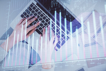 Double exposure of woman hands working on computer and forex graph hologram drawing. Top View. Financial analysis concept.